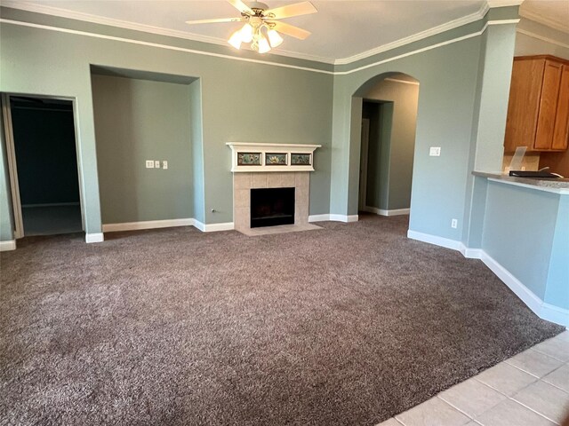 3318 Misty Alcove Ct, Kingwood, TX 77345 - unfurnished living room with crown molding, light carpet, ceiling fan, arched walkways, and a fireplace