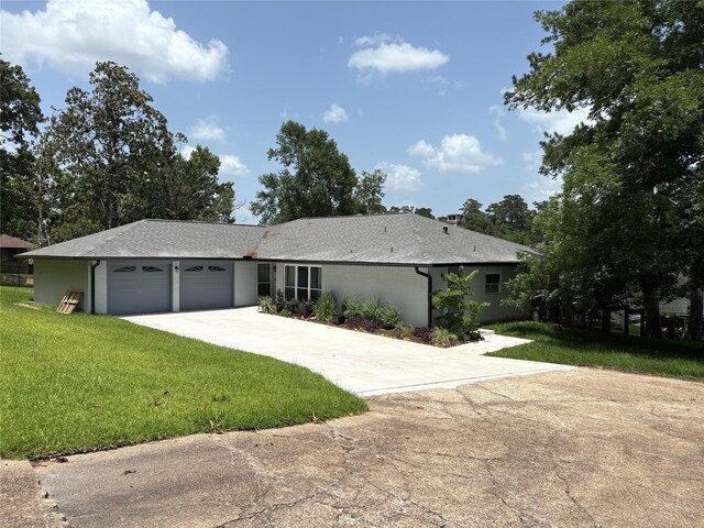 230 W Lake Dr, Livingston, TX 77351 - single story home with concrete driveway, an attached garage, a front yard, and roof with shingles