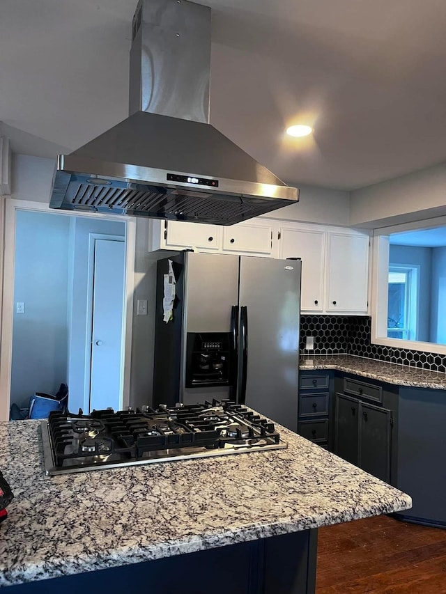 230 W Lake Dr, Livingston, TX 77351 - kitchen with wall chimney range hood, appliances with stainless steel finishes, dark wood-style flooring, light stone countertops, and white cabinets
