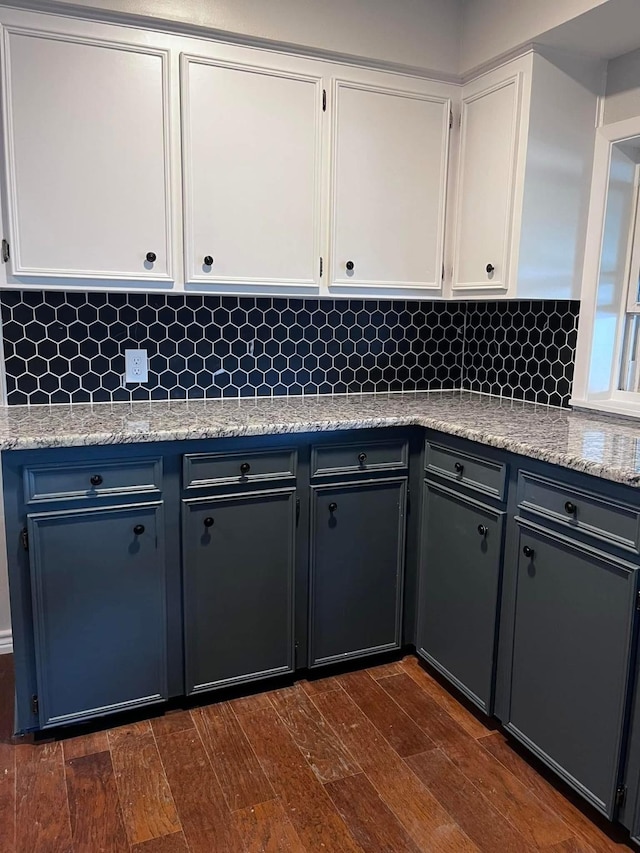 230 W Lake Dr, Livingston, TX 77351 - kitchen with white cabinets, tasteful backsplash, dark wood-type flooring, and light stone countertops