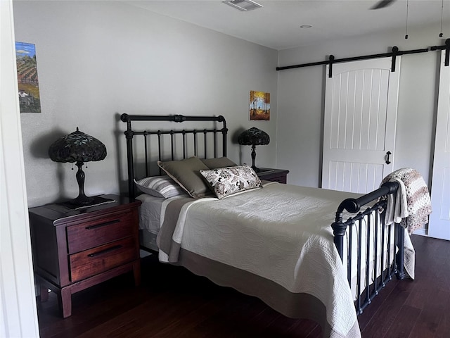 230 W Lake Dr, Livingston, TX 77351 - bedroom featuring a barn door and wood finished floors