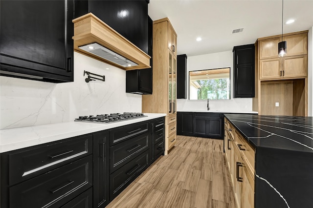 200 Rd 6615, Dayton, TX 77535 - kitchen featuring stainless steel gas stovetop, dark cabinetry, tasteful backsplash, light wood-type flooring, and recessed lighting