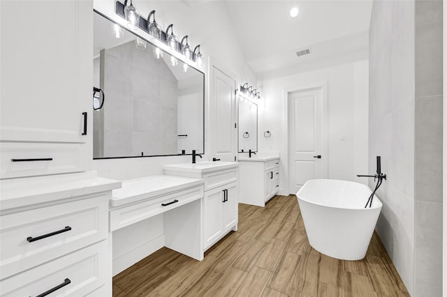 200 Rd 6615, Dayton, TX 77535 - full bathroom featuring two vanities, a freestanding tub, lofted ceiling, and wood finished floors