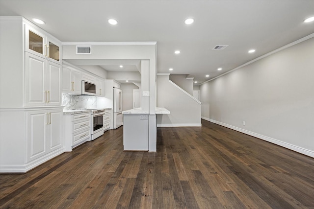 974 Memorial Village Dr Unit 53, Houston, TX 77024 - kitchen with white appliances, ornamental molding, white cabinetry, dark wood-style flooring, and recessed lighting