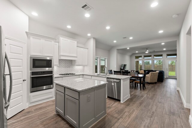 19838 Blue Roan Dr, Tomball, TX 77377 - kitchen featuring stainless steel appliances, a peninsula, a kitchen island, healthy amount of natural light, and recessed lighting