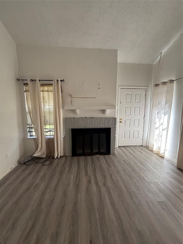6347 Cattails Ln Unit 63, Houston, TX 77035 - unfurnished living room with a fireplace, a textured ceiling, and wood finished floors