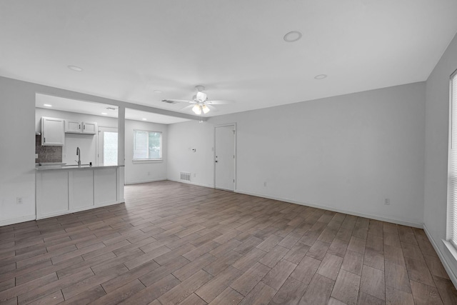 4707 Dove Springs Dr, Austin, TX 78744 - unfurnished living room featuring a ceiling fan, wood finished floors, and recessed lighting