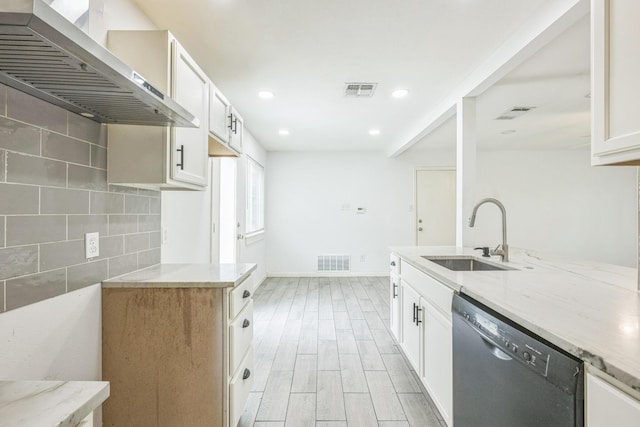 4707 Dove Springs Dr, Austin, TX 78744 - kitchen featuring dishwasher, wall chimney range hood, light stone counters, decorative backsplash, and white cabinets