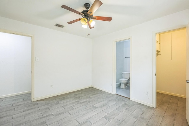 4707 Dove Springs Dr, Austin, TX 78744 - unfurnished bedroom featuring a walk in closet, light wood-style floors, ensuite bath, and ceiling fan