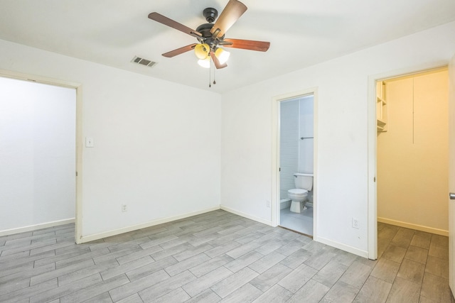4707 Dove Springs Dr, Austin, TX 78744 - unfurnished bedroom featuring a spacious closet, wood finish floors, ensuite bathroom, and ceiling fan