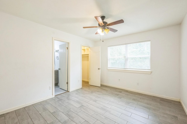 4707 Dove Springs Dr, Austin, TX 78744 - unfurnished bedroom with a walk in closet, light wood-type flooring, ensuite bath, and ceiling fan