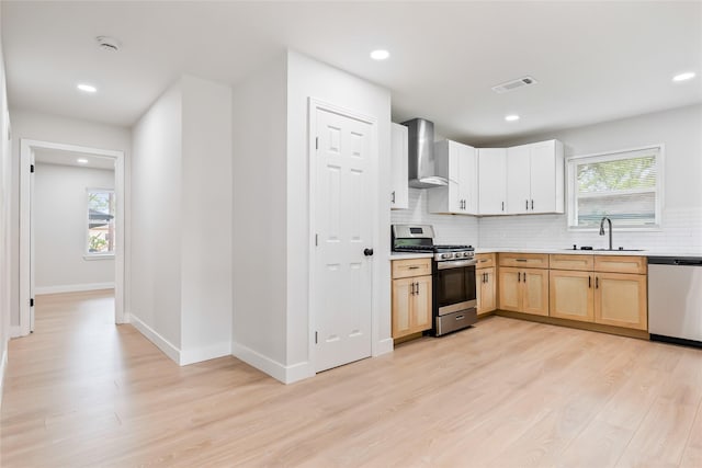 153 E Rittenhouse St, Houston, TX 77076 - kitchen with appliances with stainless steel finishes, wall chimney exhaust hood, light wood-style floors, tasteful backsplash, and recessed lighting