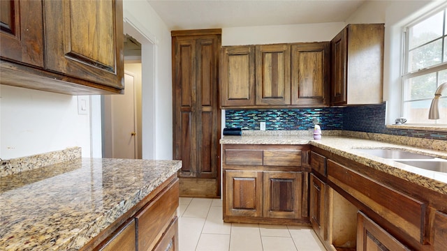907 Axilda St, Houston, TX 77017 - kitchen featuring light tile patterned floors, tasteful backsplash, and light stone counters
