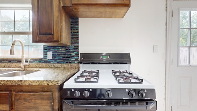 907 Axilda St, Houston, TX 77017 - kitchen featuring gas stove, backsplash, and light stone countertops