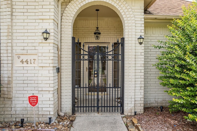 4417 Alamance St, Baytown, TX 77521 - entrance to property with brick siding, a shingled roof, and a gate