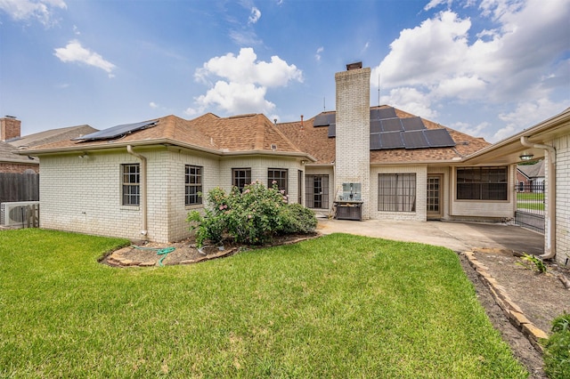 4417 Alamance St, Baytown, TX 77521 - back of house featuring solar panels, a patio, a chimney, and brick siding