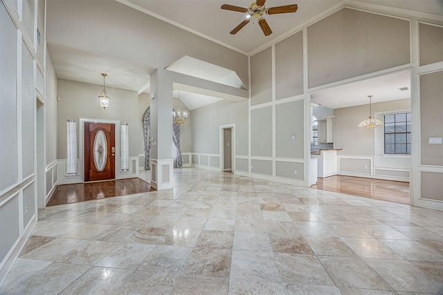 4417 Alamance St, Baytown, TX 77521 - entryway with a decorative wall, a high ceiling, ceiling fan, a chandelier, and wainscoting