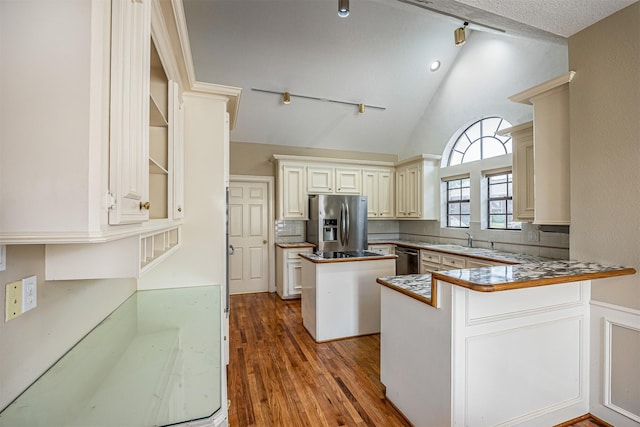 4417 Alamance St, Baytown, TX 77521 - kitchen with stainless steel appliances, wood finished floors, tasteful backsplash, a peninsula, and rail lighting