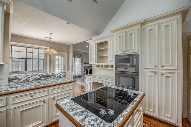 4417 Alamance St, Baytown, TX 77521 - kitchen with appliances with stainless steel finishes, cream cabinets, wood finished floors, decorative light fixtures, and lofted ceiling
