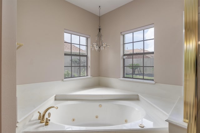 4417 Alamance St, Baytown, TX 77521 - bathroom featuring a jetted tub and a chandelier