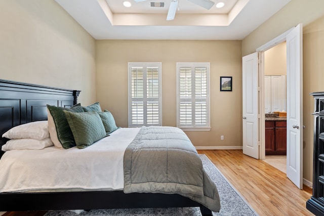 3908 Center St, Houston, TX 77007 - bedroom with light wood-style floors, a tray ceiling, connected bathroom, and recessed lighting