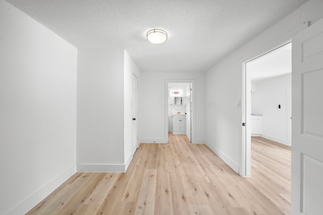 7711 Greenstone St, Houston, TX 77087 - hall with light wood-style flooring and a textured ceiling