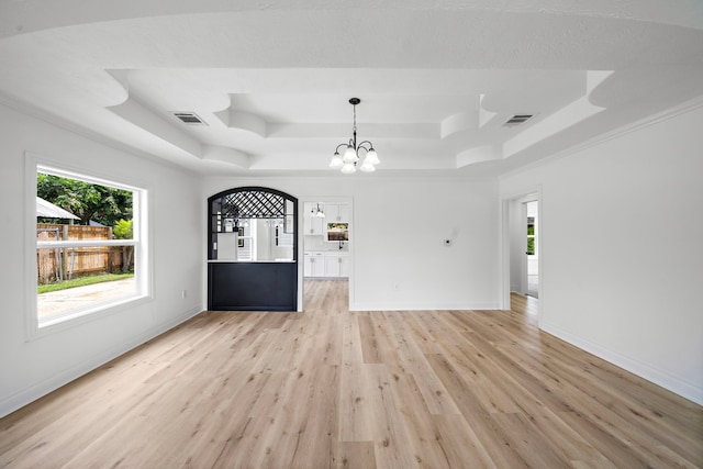 7711 Greenstone St, Houston, TX 77087 - unfurnished living room with a raised ceiling, light wood-style flooring, a chandelier, and healthy amount of natural light
