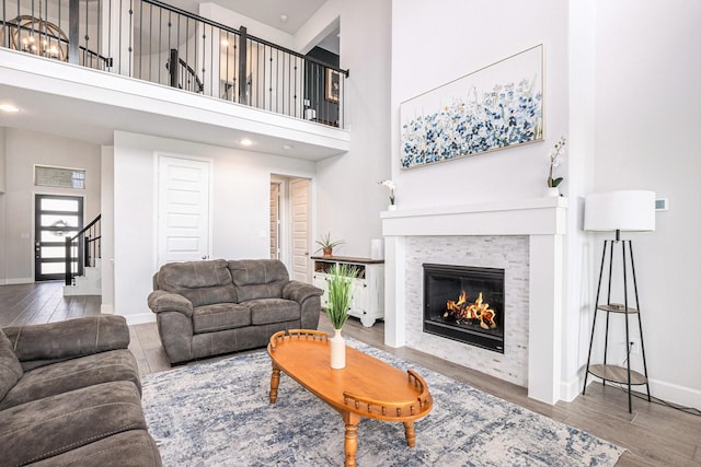 3119 Honeysuckle Way, Katy, TX 77493 - living area with a glass covered fireplace, stairs, wood finished floors, a towering ceiling, and recessed lighting