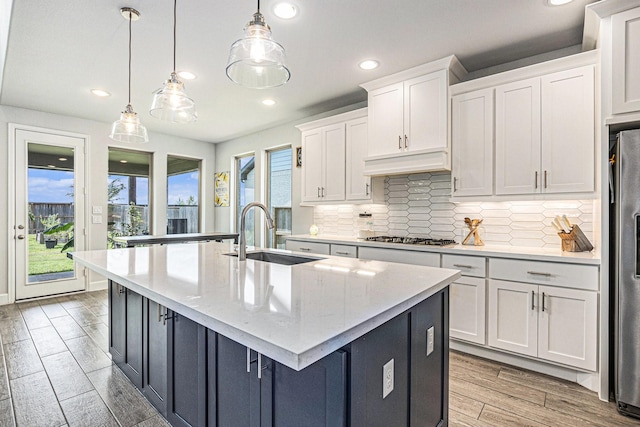 3119 Honeysuckle Way, Katy, TX 77493 - kitchen with white cabinets, tasteful backsplash, a kitchen island with sink, appliances with stainless steel finishes, and recessed lighting