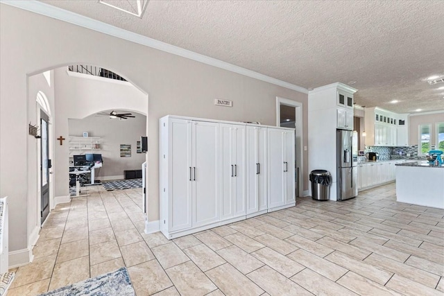 20012 Fm 523, Angleton, TX 77515 - kitchen with stainless steel fridge, arched walkways, white cabinets, glass insert cabinets, and a textured ceiling