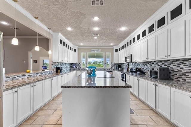 20012 Fm 523, Angleton, TX 77515 - kitchen with appliances with stainless steel finishes, backsplash, a center island, white cabinetry, and ornamental molding