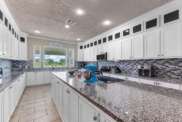 20012 Fm 523, Angleton, TX 77515 - kitchen featuring stainless steel appliances, crown molding, white cabinets, tasteful backsplash, and dark stone counters