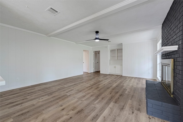 910 Woodchurch Ln, Houston, TX 77073 - unfurnished living room featuring wood finished floors, a brick fireplace, ceiling fan, crown molding, and a textured ceiling