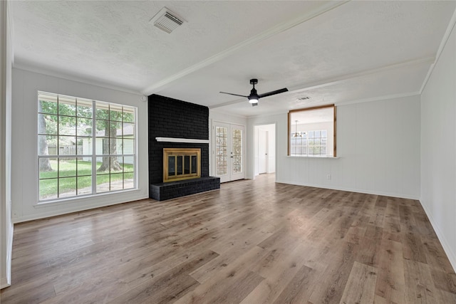 910 Woodchurch Ln, Houston, TX 77073 - unfurnished living room with plenty of natural light, ceiling fan, a brick fireplace, wood finished floors, and a textured ceiling