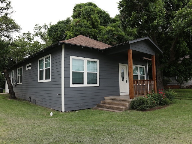 1306 S Austin St, Brenham, TX 77833 - bungalow-style home with a front yard, roof with shingles, and covered porch