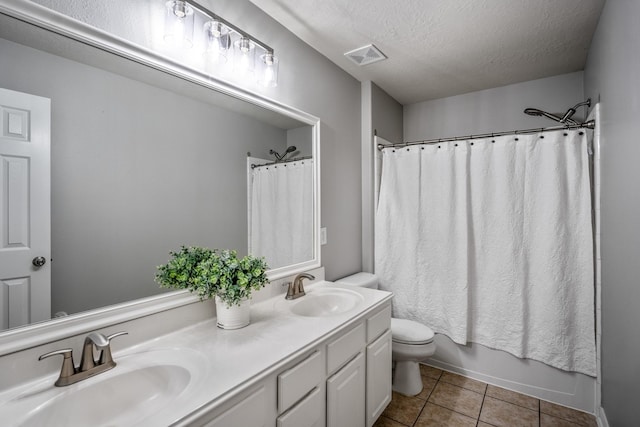 7214 Emerald Run Ln, Spring, TX 77379 - full bathroom with double vanity, tile patterned floors, a textured ceiling, and shower / tub combo