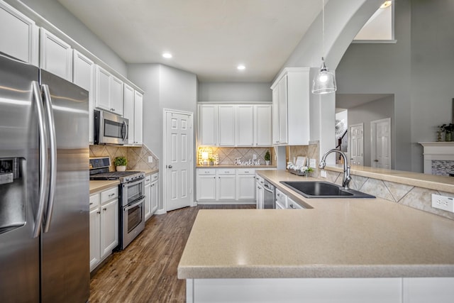 7214 Emerald Run Ln, Spring, TX 77379 - kitchen with stainless steel appliances, light countertops, dark wood finished floors, white cabinets, and recessed lighting