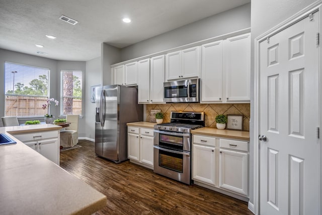 7214 Emerald Run Ln, Spring, TX 77379 - kitchen featuring stainless steel appliances, recessed lighting, decorative backsplash, white cabinets, and dark wood-style floors