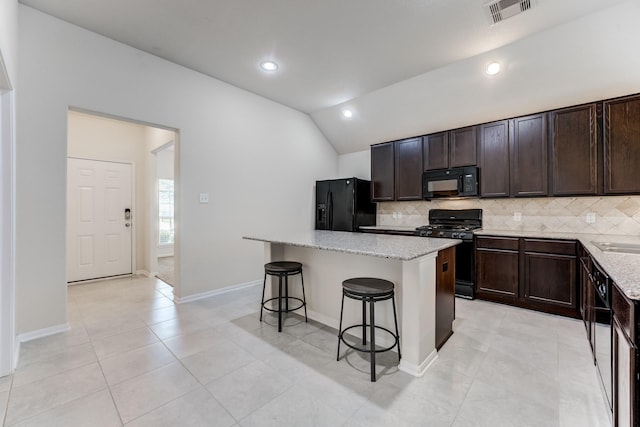 14726 Lark Sky Way, Cypress, TX 77429 - kitchen featuring black appliances, decorative backsplash, a breakfast bar, vaulted ceiling, and a kitchen island