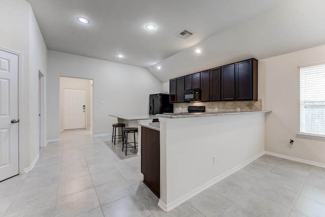 14726 Lark Sky Way, Cypress, TX 77429 - kitchen featuring black appliances, decorative backsplash, a peninsula, vaulted ceiling, and light tile patterned floors