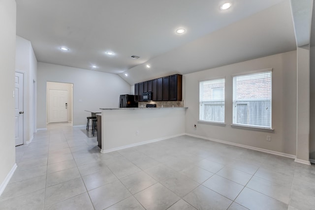 14726 Lark Sky Way, Cypress, TX 77429 - kitchen with black appliances, lofted ceiling, light tile patterned flooring, recessed lighting, and backsplash