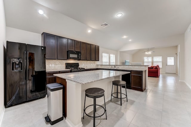 14726 Lark Sky Way, Cypress, TX 77429 - kitchen featuring black appliances, a center island, decorative backsplash, a peninsula, and dark brown cabinetry