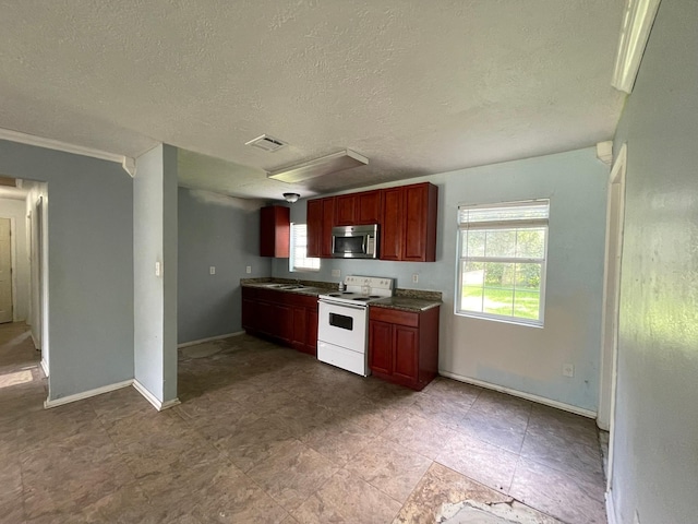 5746 Groveton St, Houston, TX 77033 - kitchen featuring electric range, stainless steel microwave, a textured ceiling, dark countertops, and reddish brown cabinets