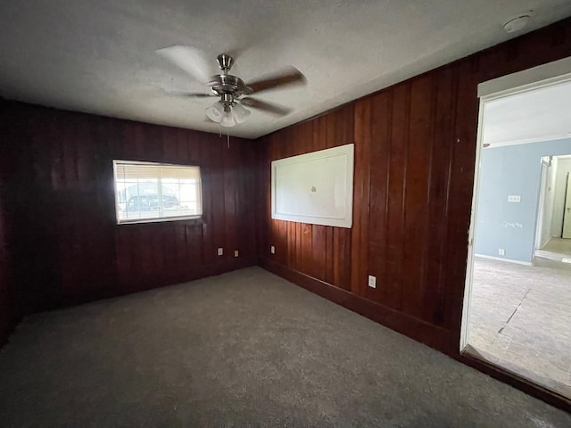 5746 Groveton St, Houston, TX 77033 - spare room featuring a ceiling fan, wood walls, carpet, and a smoke detector