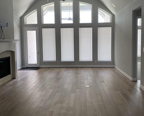 19007 Dappled Mare Cir, Tomball, TX 77377 - unfurnished living room featuring lofted ceiling, wood finished floors, a fireplace, and a ceiling fan