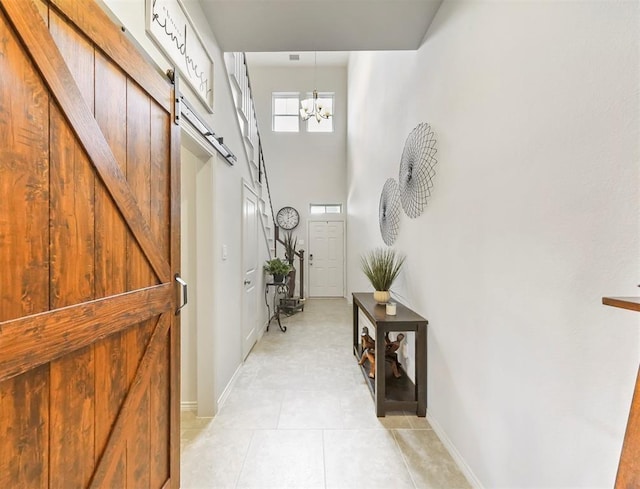 17023 Canosa Dr, Cypress, TX 77433 - hall featuring a barn door, a chandelier, light tile patterned floors, and a high ceiling
