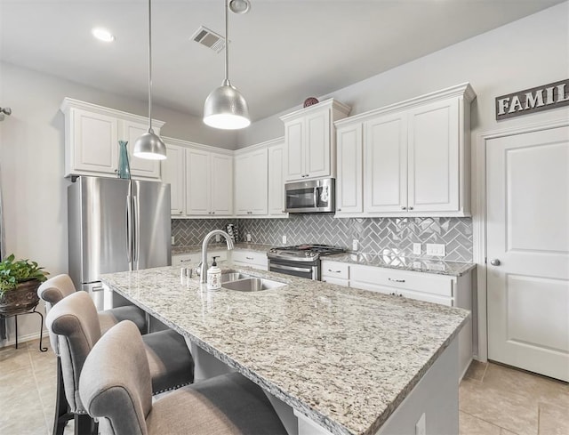 17023 Canosa Dr, Cypress, TX 77433 - kitchen with appliances with stainless steel finishes, an island with sink, backsplash, and a breakfast bar