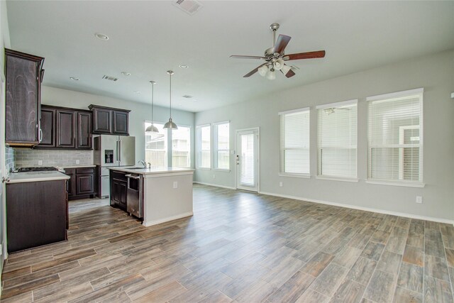 17019 Canosa Dr, Cypress, TX 77433 - kitchen with stainless steel appliances, open floor plan, ceiling fan, light countertops, and dark brown cabinetry