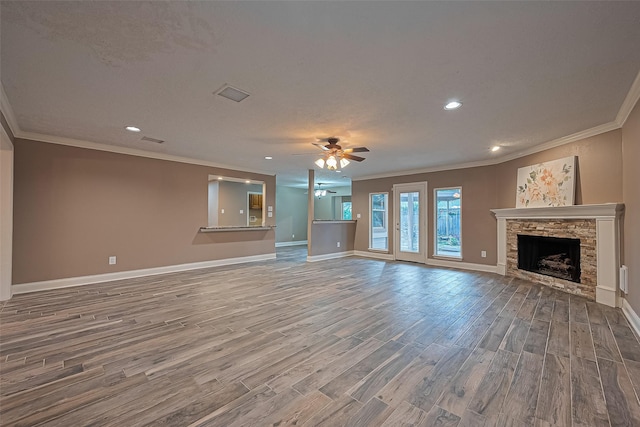5942 Pebble Springs Dr, Houston, TX 77066 - unfurnished living room with ornamental molding, wood finished floors, a ceiling fan, a stone fireplace, and recessed lighting