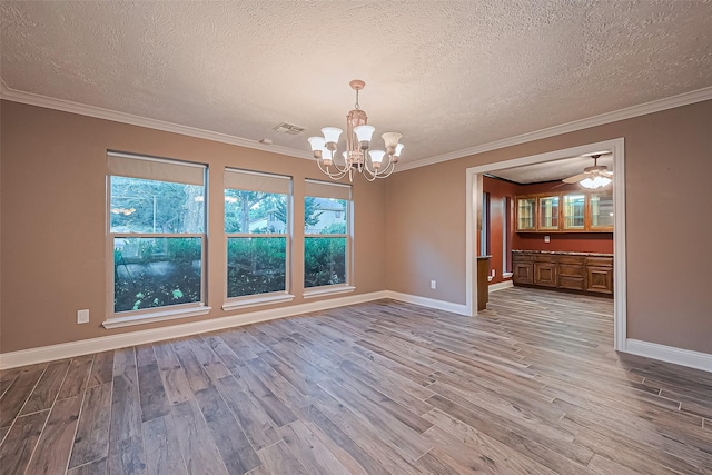 5942 Pebble Springs Dr, Houston, TX 77066 - empty room with a chandelier, wood finished floors, a textured ceiling, and crown molding